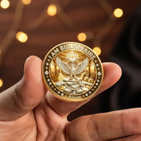 A hand holding a gold-colored commemorative coin that reads 'I AM BILLIONAIRE' with an eagle and stacks of money in the center, set against a warm, blurred background with bokeh lights.