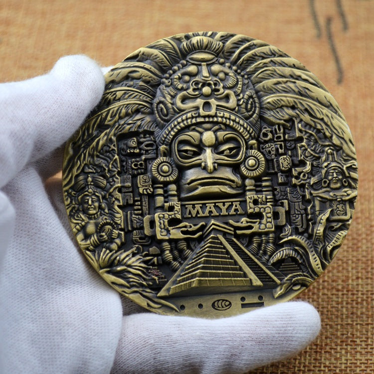 Ancient Mayan calendar bronze coin held in hand showing 80mm size and intricate deity mask design with gold highlights