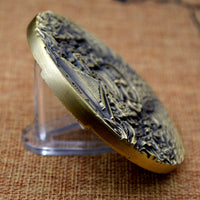 Ancient Mayan calendar bronze coin shown on edge displaying 10mm thickness and detailed relief work