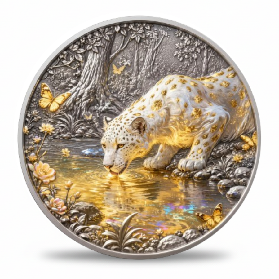 A round silver-toned coin featuring a detailed relief of a white leopard with gold spots drinking from a reflective pool of water, surrounded by butterflies, flowers, and a forest scene in silver and gold tones.