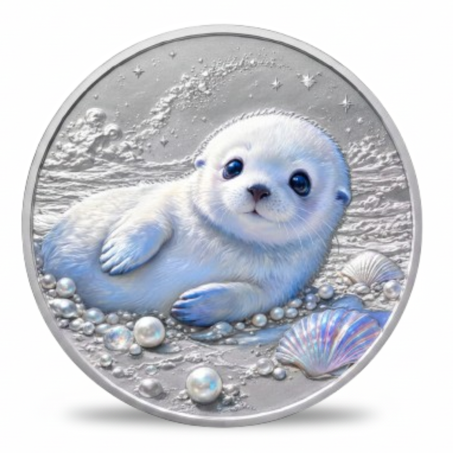 A round silver coin featuring a detailed illustration of a white seal pupp sitting among pearls, shells, and sea foam, shown on a plain white background.