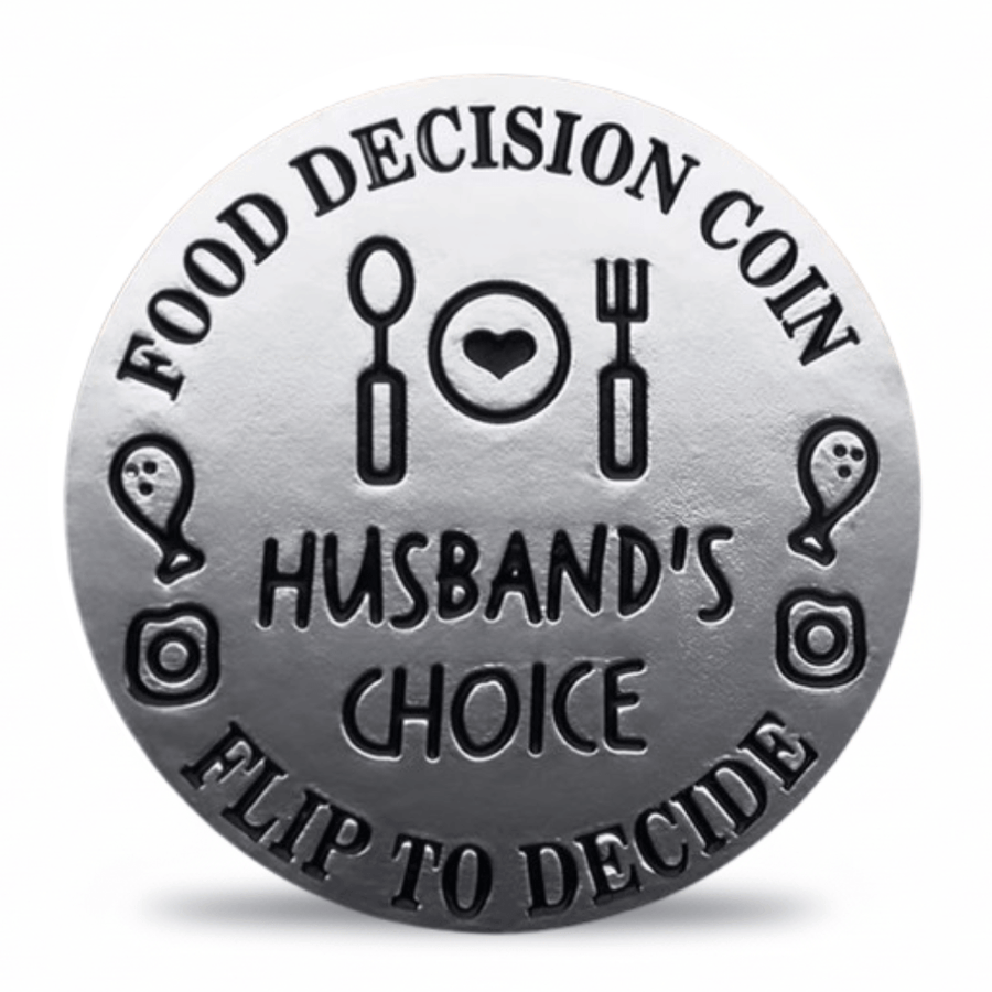 A round silver-toned coin-style token with engraved black text reading 'FOOD DECISION COIN' and 'HUSBAND'S CHOICE' plus 'FLIP TO DECIDE', surrounded by simple food and decision icons on a white background. Available at one more coin store