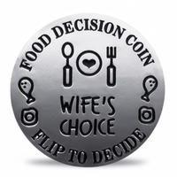 A round silver-toned metal coin-style token with engraved black text reading 'FOOD DECISION COIN' and 'FLIP TO DECIDE,' plus 'WIFE'S CHOICE' in the center and simple food-themed icons around the border.