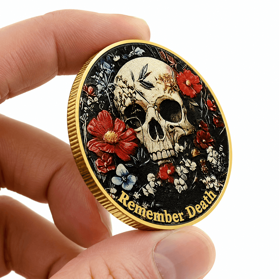 A hand holds a round commemorative coin featuring a detailed skull and floral design with the text 'Remember Death' along the bottom edge, set against a plain white background.