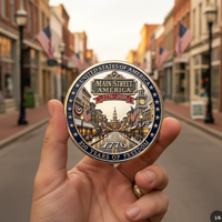 Main Street America 250th anniversary commemorative collectible coin held in hand cobblestone street scene American flags small-town USA 
