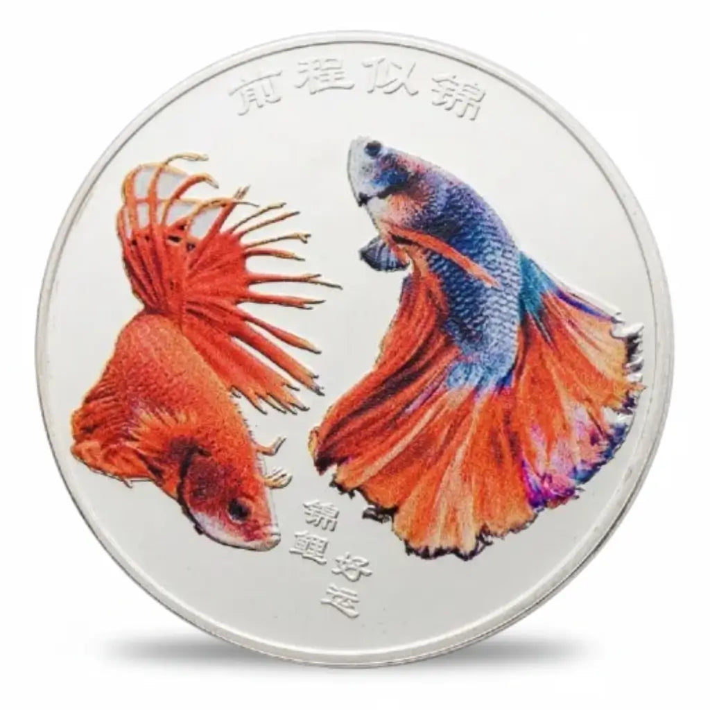Silver-tone coin featuring a red Siamese fighting fish beside a blue-purple betta with sweeping orange-red fins, set against a bright silver-coloured background with Chinese characters above and below