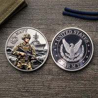 Overhead view of both military tribute coin faces side by side on weathered dark wood, with olive canvas in the upper-left corner and navy cord at the top right. The left face reads “NAVY” and shows a helmeted service member holding a rifle before a warship and rolling waves. The right reads “UNITED STATES ARMY” around a silver-tone eagle with outstretched wings, leafy branches and stars, collectible token
