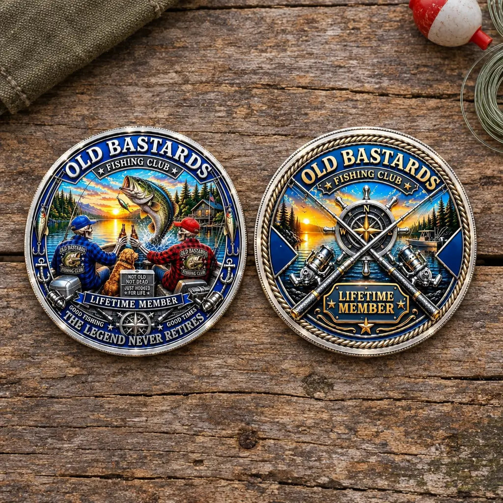 Two round metal fishing-themed coins displayed side by side on a rustic wooden surface. The left buckle features a colorful illustration of two fishermen, a large fish, and the text 'OLD BASTARDS FISHING CLUB V LIFETIME MEMBER THE LEGEND NEVER RETIRES'.
