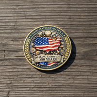 Breaking Through 250 Years USA patriotic collectible coin lying flat on worn wooden surface natural daylight commemorative collectible token lifestyle shot
