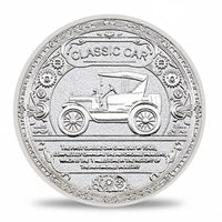 Silver coin with a design of a classic car and engraved text on a white background