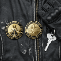 Two round gold-tone motorcycle-themed coins are displayed on a black leather jacket, alongside a black glove and a silver key. The left coin features an image of Jesus riding a motorcycle, and the right coin reads 'IN THE WIND WE TRUST' and 'FAITH-FREEDOM BROTHERHOOD' with a cross and 'NEVER RIDE ALONE'.
