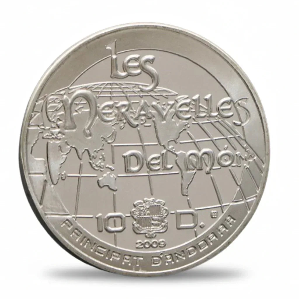 Silver coin with 'Les Merveilles Del mon' text and a globe design on a white background