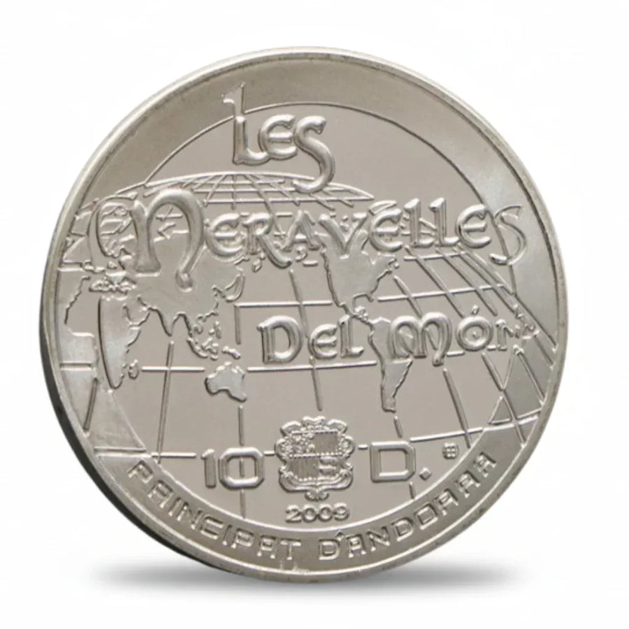 Silver coin with 'Les Merveilles Del mon' text and a globe design on a white background