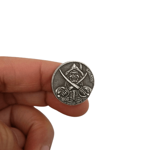 Close-up of pirate skull hobo nickel collectible coin token showing antique silver-tone relief detail
