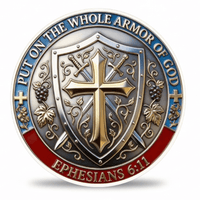 A circular religious coin featuring a central shield with a gold cross, crossed swords, grapes, and ornate scrollwork. The outer ring has blue and red sections with the text 'PUT ON THE WHOLE ARMOR OF GOD' and 'EPHESIANS 6:11'.