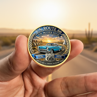 Hand holding Route 66 centennial commemorative collectible coin gold finish desert highway background Americana collectible token