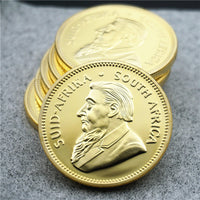 South African Krugerrand gold-tone replica coins stacked Paul Kruger portrait collectible coin display available at One More Coin store
