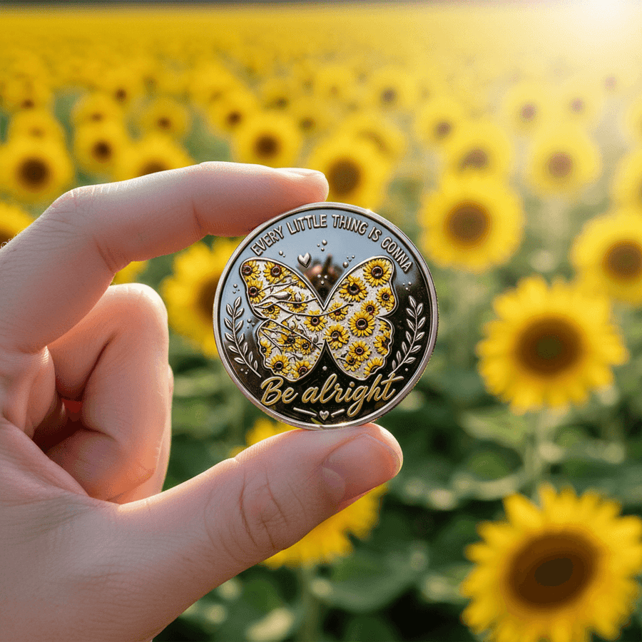 Hand holding sunflower butterfly challenge coin in front of sunflower field collectible token gift
