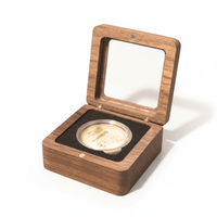 Walnut coin display box with black velvet interior holding a gold collectible coin.
