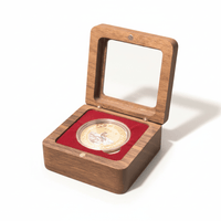 Walnut coin display box with crimson velvet interior holding a gold collectible coin on white background
