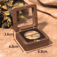Wooden box with a coin inside, showing measurements on a textured surface.