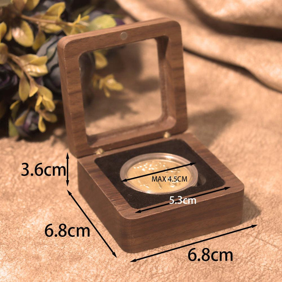 Wooden box with a coin inside, showing measurements on a textured surface.
