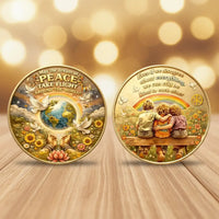 Two round commemorative coins displayed side by side on a wooden surface with a warm bokeh background. The left coin shows a globe, doves, flowers, and the text 'May the dream of PEACE TAKE FLIGHT AROUND THE WORLD!'.
