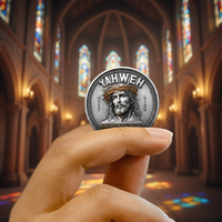 A hand holds a silver-colored religious coin featuring an illustration of Jesus with a crown of thorns and the word 'YAHWEH' at the top, set against a blurred background of a cathedral interior with stained glass windows.